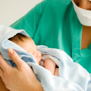 A picture of a baby and midwife for our article on the educational path to becoming a midwife